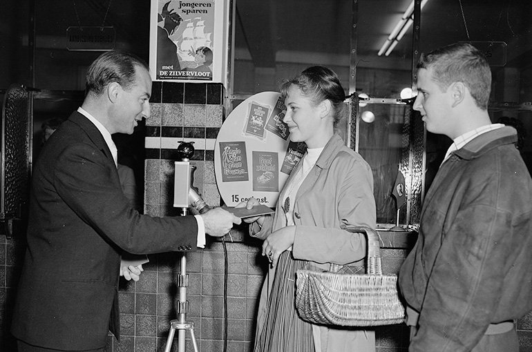Minister Jo Cals (links) feliciteert jongeren met het openen van een Zilvervlootrekening, 1958.